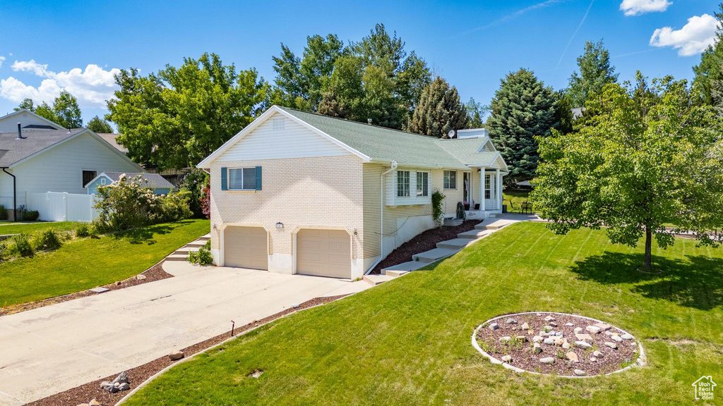 View of front facade with an attached garage, driveway, and a front yard