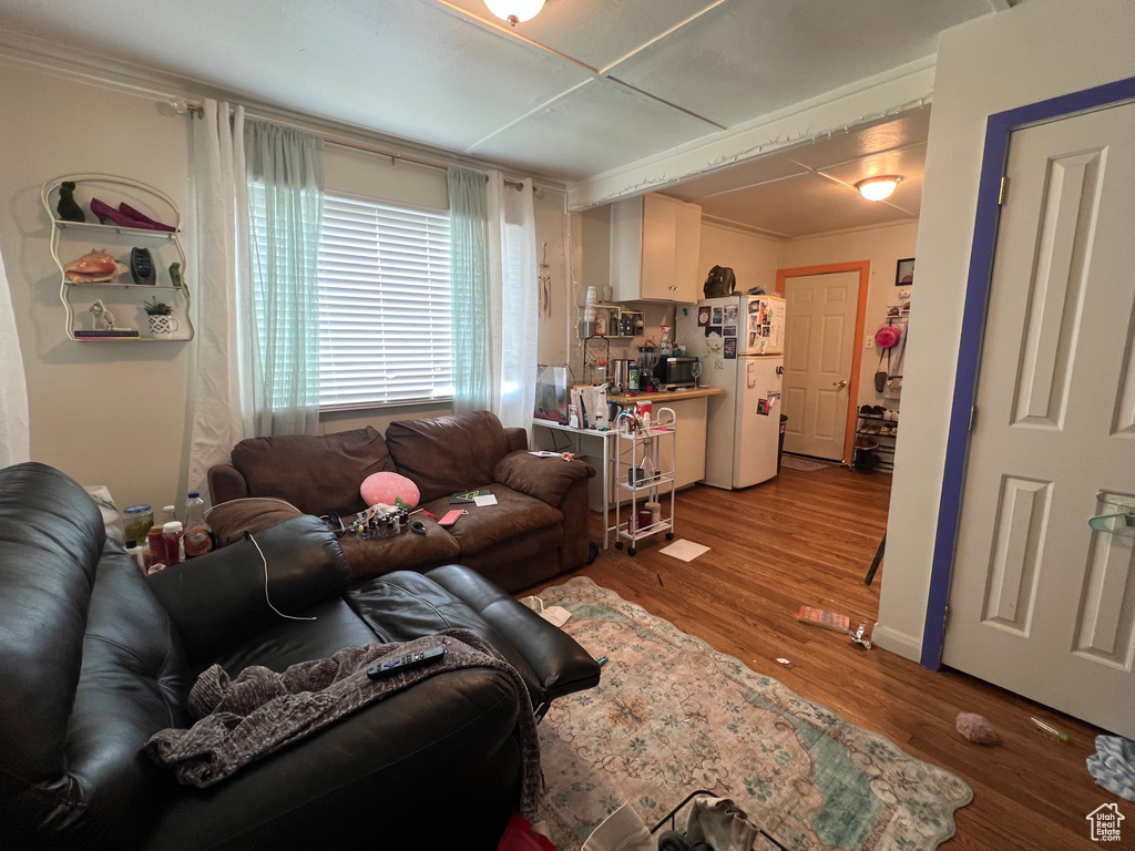 Living area featuring wood finished floors and crown molding