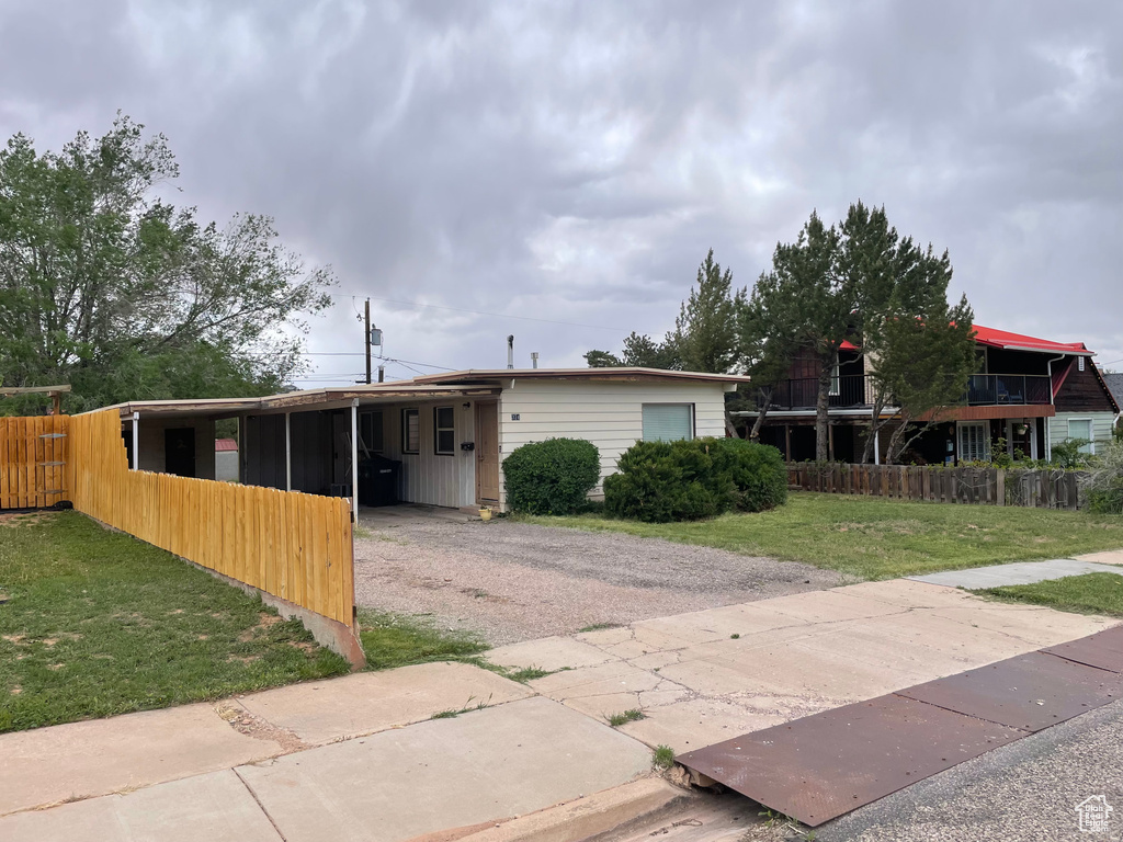 Back of house featuring driveway and a carport
