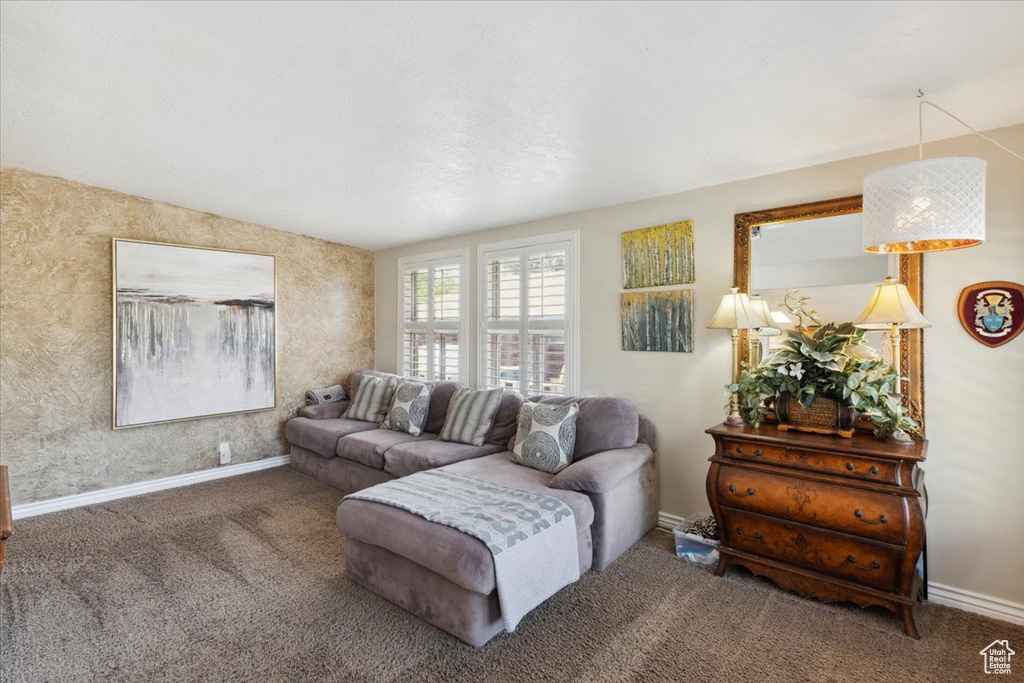 Living room featuring carpet, baseboards, and lofted ceiling