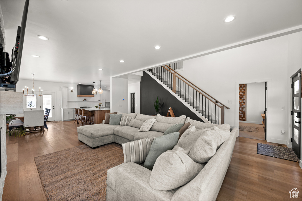 Living room with a chandelier, stairway, hardwood / wood-style flooring, and recessed lighting