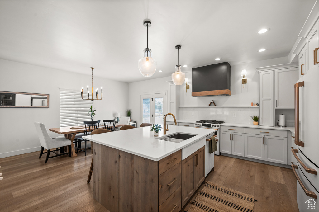 Kitchen featuring a sink, premium range hood, stainless steel gas stove, open shelves, and recessed lighting