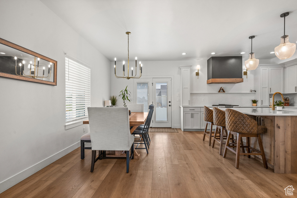 Dining space featuring a chandelier, recessed lighting, light wood-style floors, and baseboards