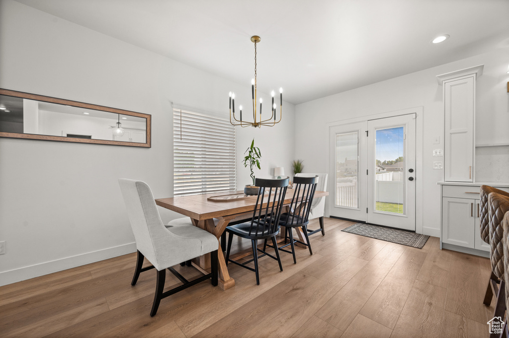 Dining space with a chandelier, light wood-style flooring, baseboards, and recessed lighting