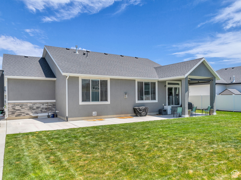 Back of property featuring a patio area, stucco siding, and a shingled roof