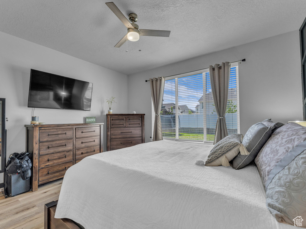 Bedroom featuring wood finished floors, a textured ceiling, and a ceiling fan