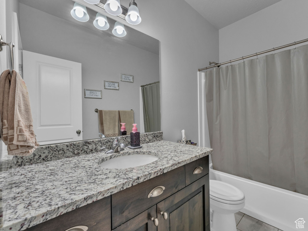 Bathroom with vanity, toilet, shower / bath combo, and tile patterned floors