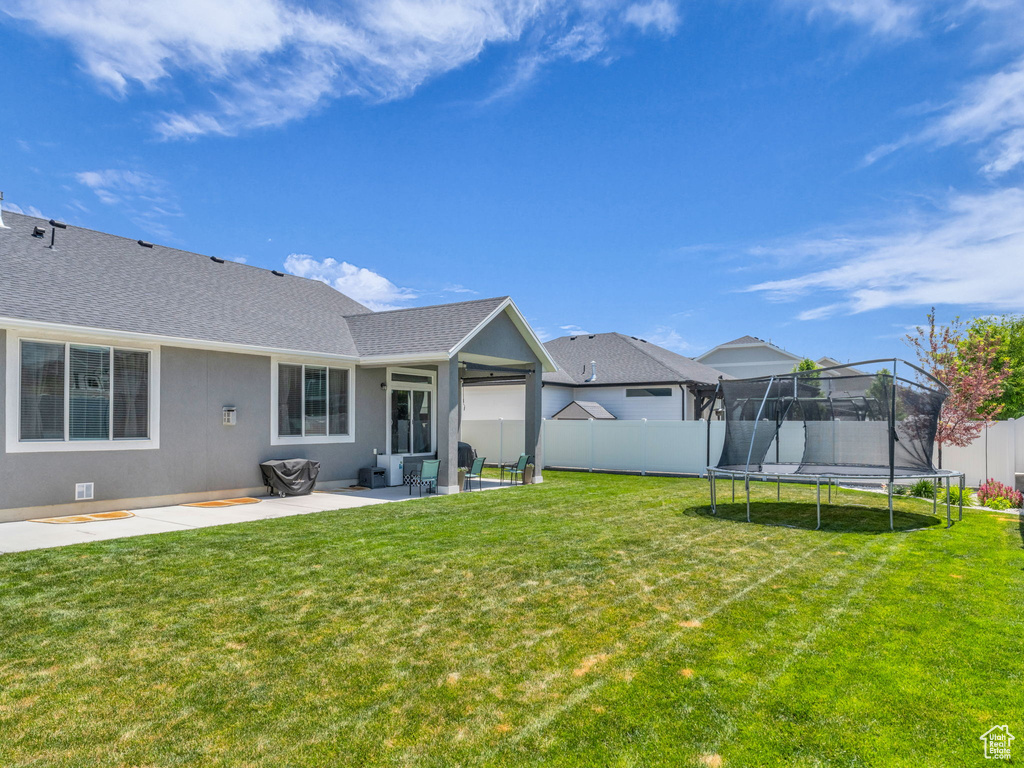 View of yard with a trampoline and a patio area