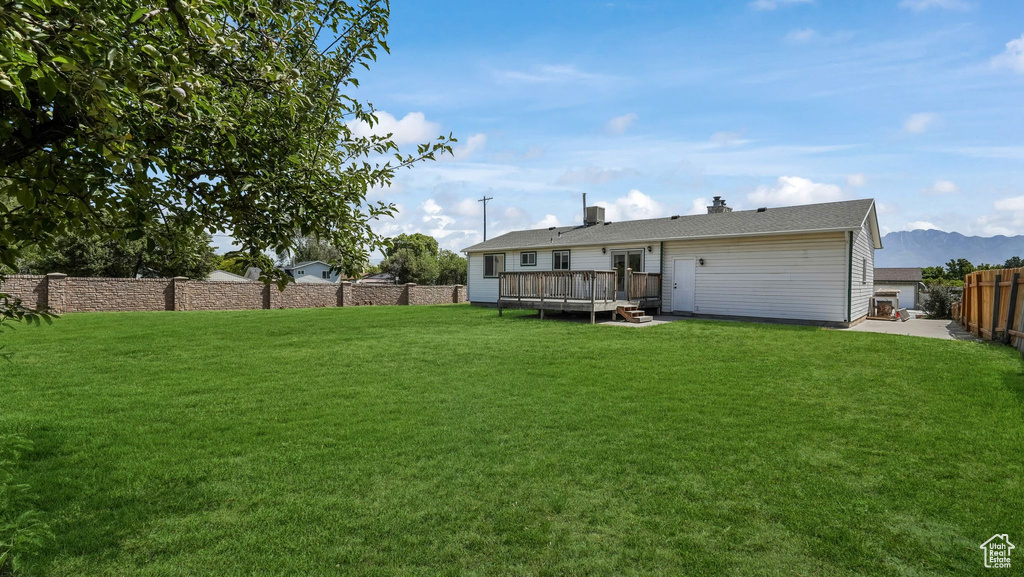 Back of property with a deck with mountain view and a chimney