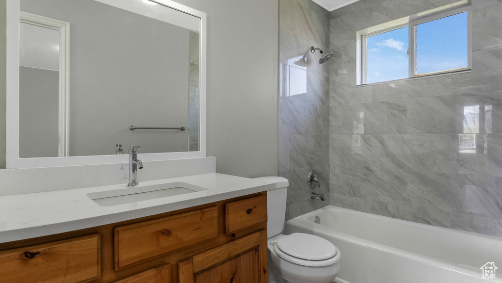 Full bath with tub / shower combination, vanity, and toilet