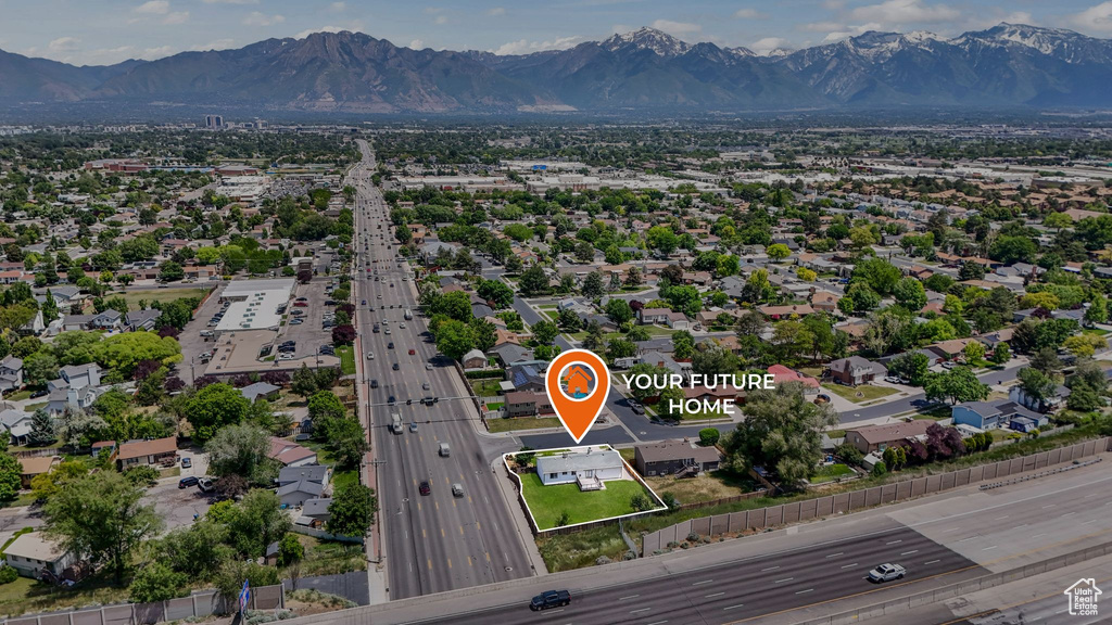 Aerial overview of property's location featuring a mountainous background and a main thoroughfare