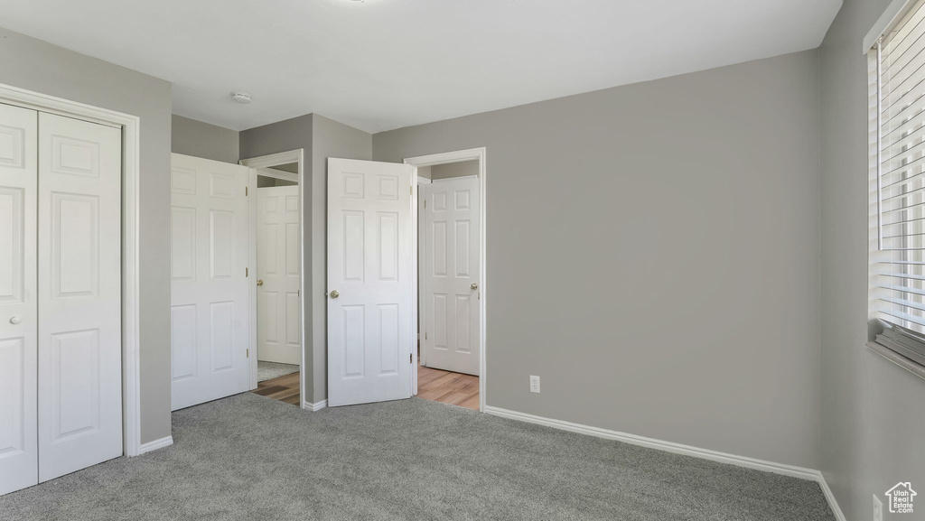 Unfurnished bedroom with carpet flooring, baseboards, and a closet