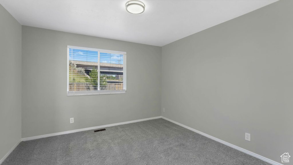 Carpeted spare room with baseboards