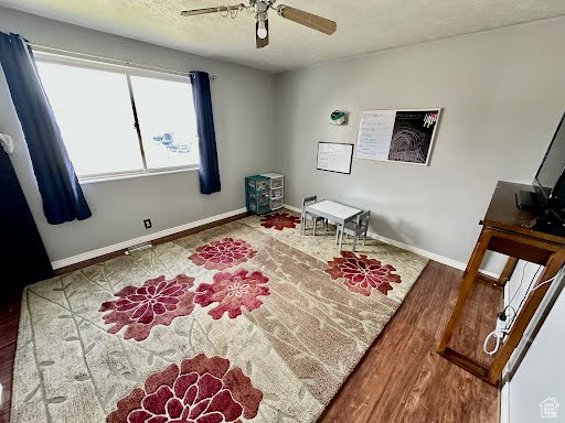 Interior space featuring wood finished floors, baseboards, and a ceiling fan
