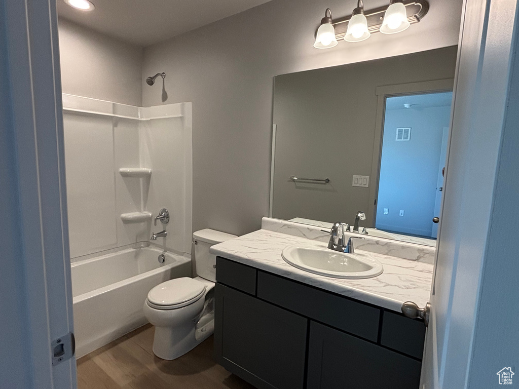Full bathroom featuring vanity, toilet, shower / bathtub combination, and wood finished floors