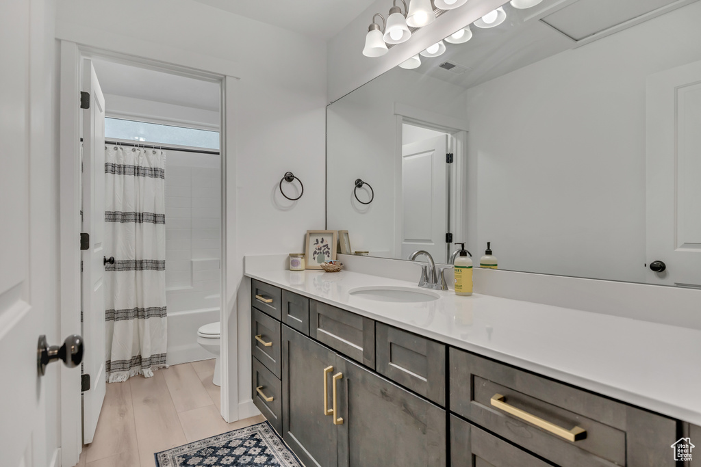 Bathroom featuring toilet, vanity, and shower / tub combo