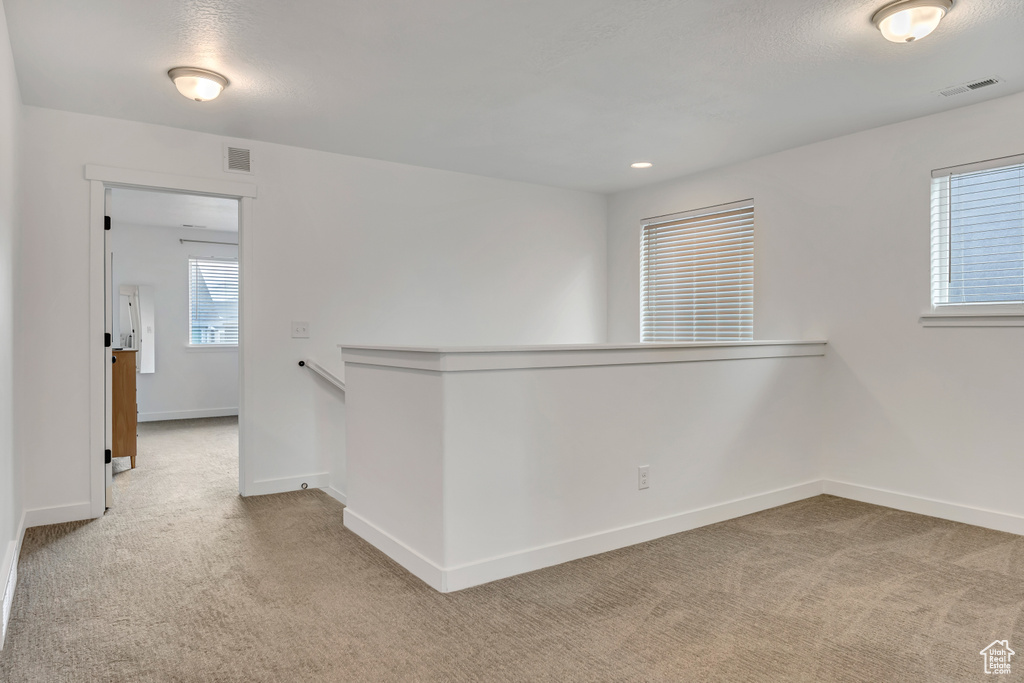 Carpeted spare room featuring baseboards
