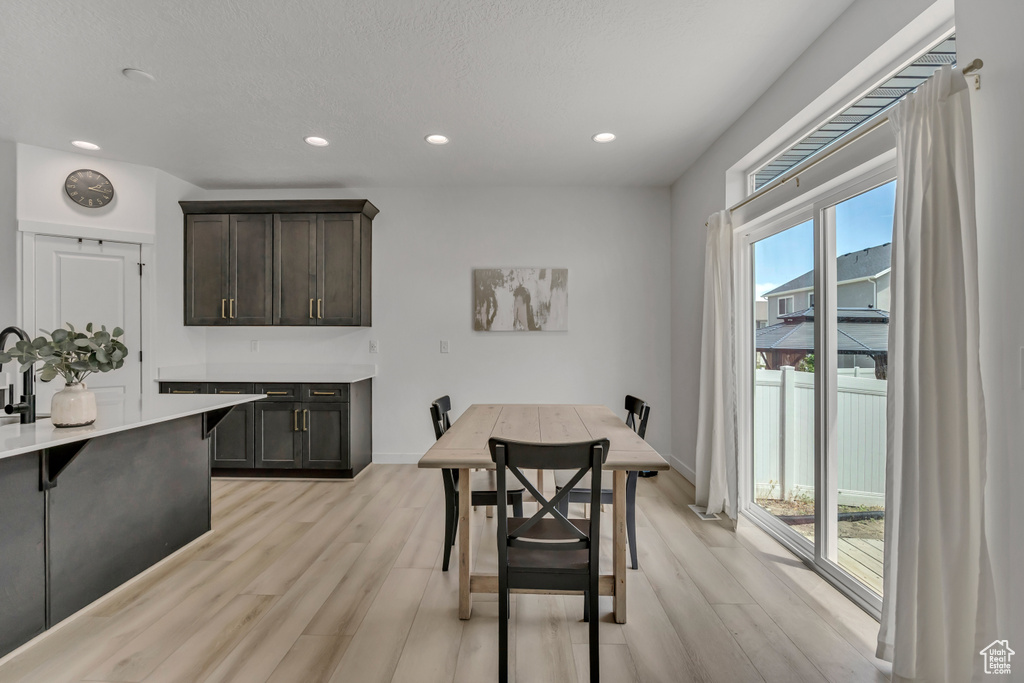 Dining area with light wood-style flooring, recessed lighting, and baseboards