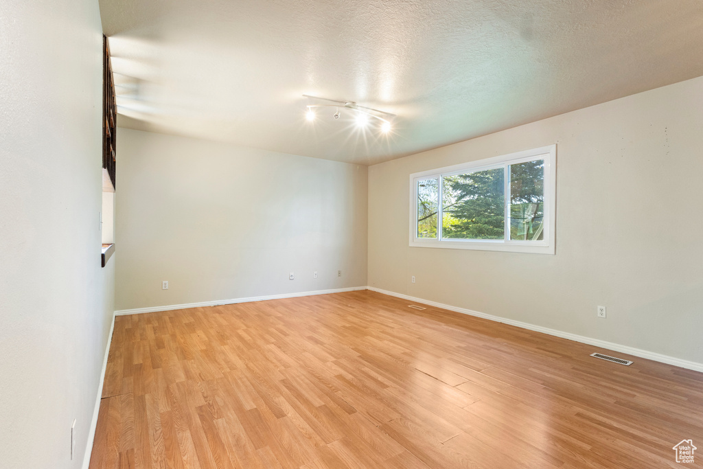 Spare room featuring light wood-style floors and baseboards