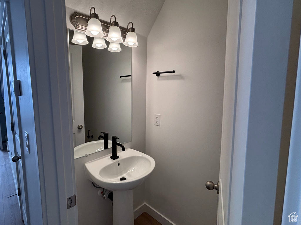 Bathroom featuring lofted ceiling, wood finished floors, and baseboards
