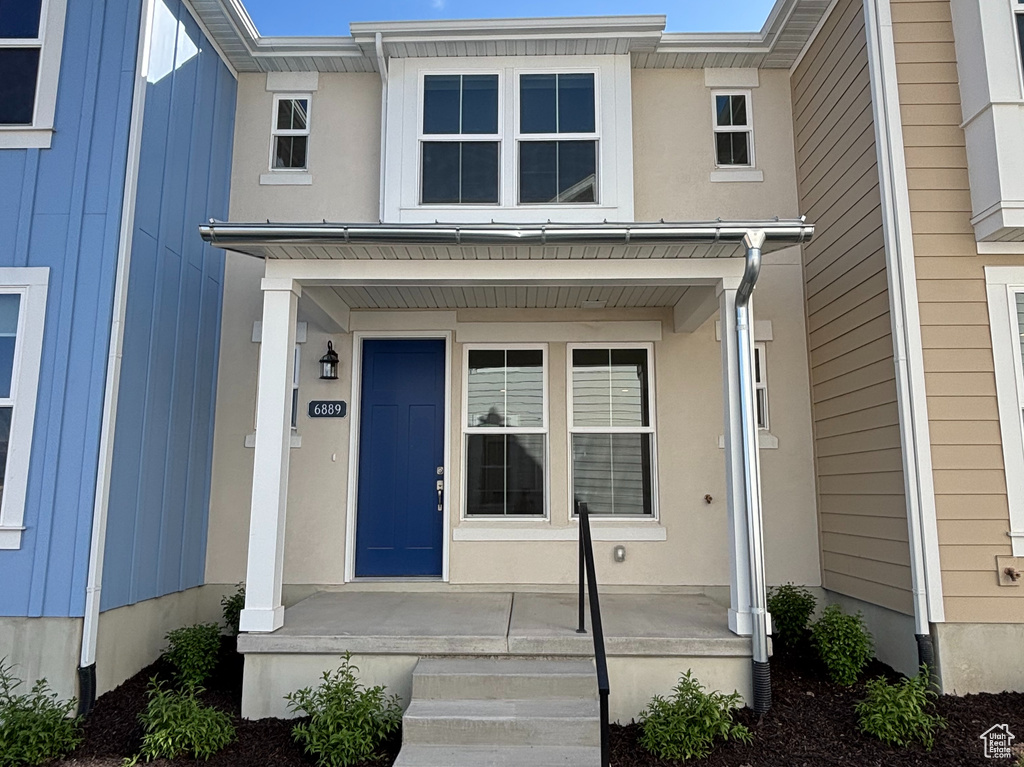 View of front facade with a porch and board and batten siding