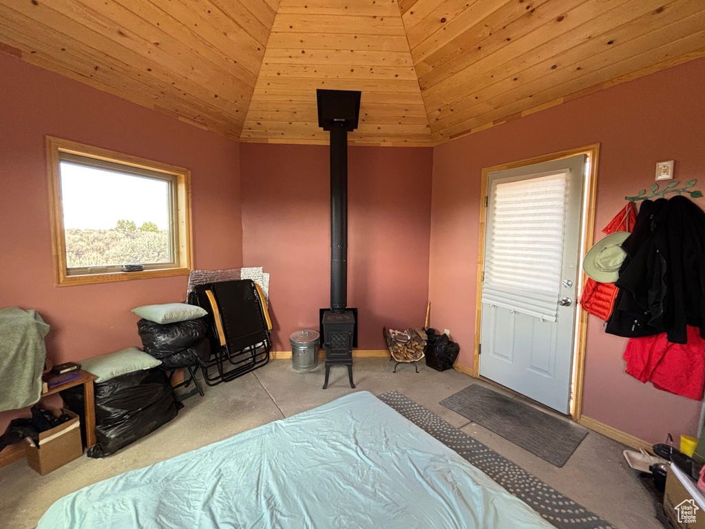 Bedroom with carpet, a wood stove, wooden ceiling, vaulted ceiling, and baseboards