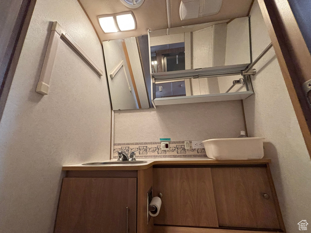 Bathroom featuring vanity and a textured wall