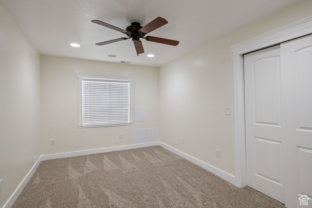Empty room featuring ceiling fan, light colored carpet, baseboards, and recessed lighting