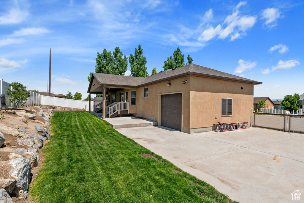 View of front of home with an attached garage, driveway, and stucco siding