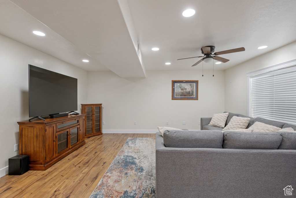 Living area featuring a ceiling fan, light wood finished floors, baseboards, and recessed lighting