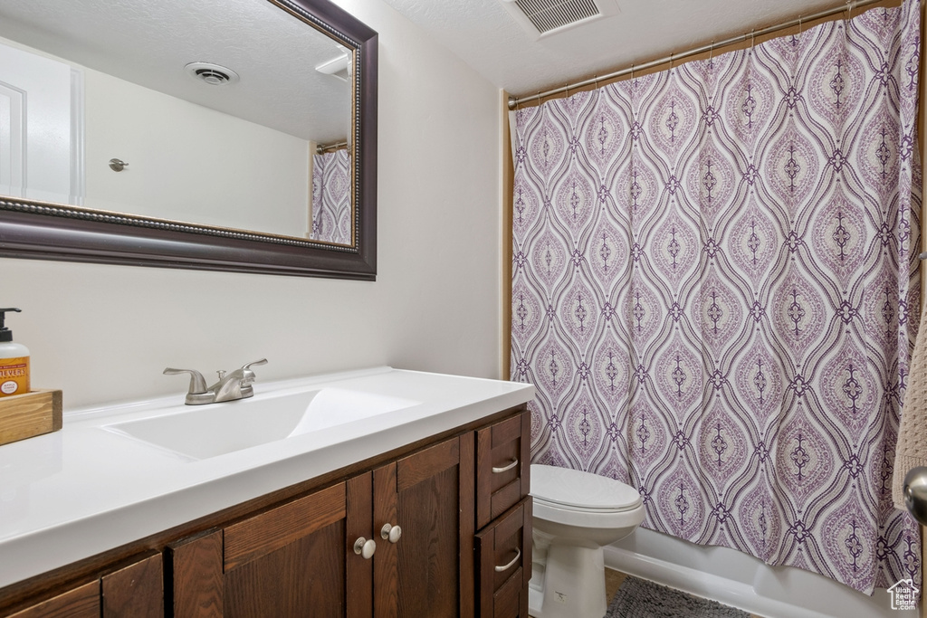 Full bathroom with vanity, toilet, and a shower with curtain