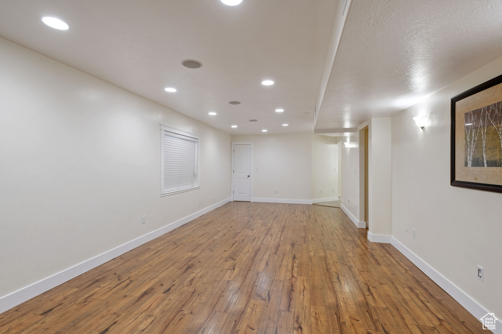 Empty room featuring hardwood / wood-style floors, recessed lighting, and baseboards