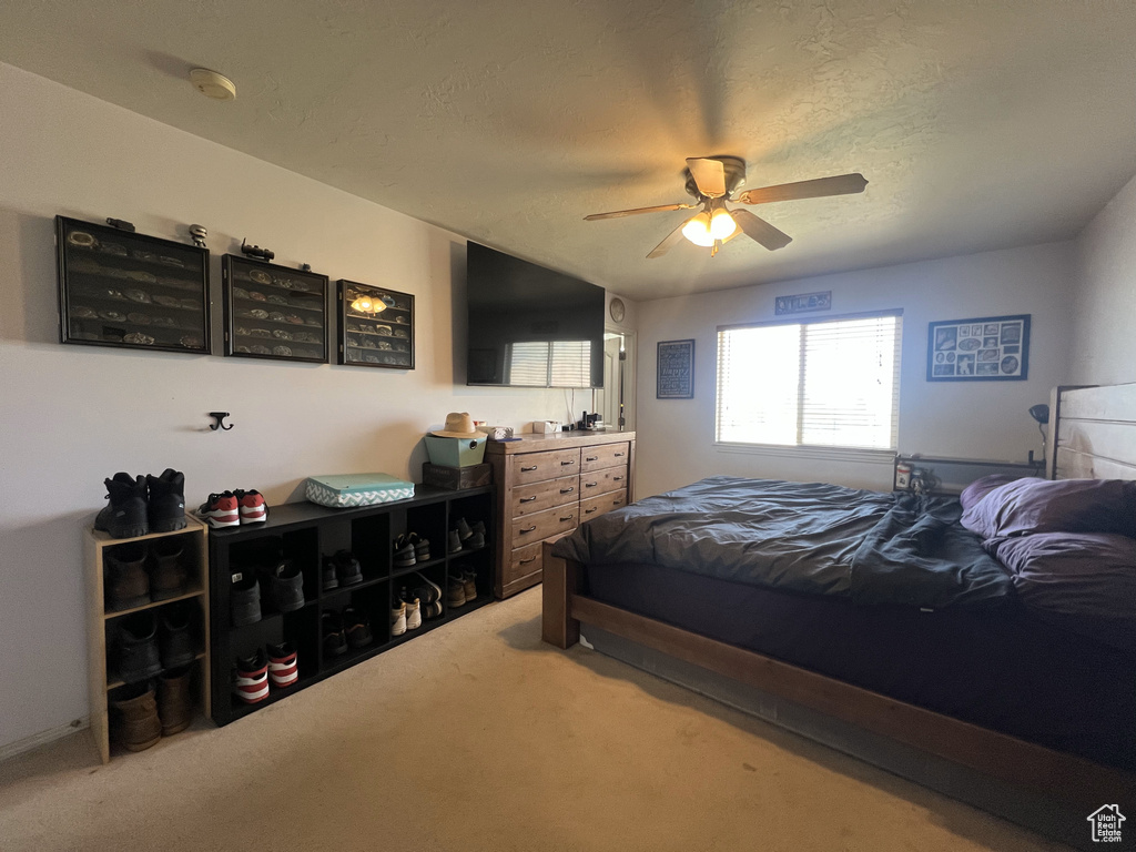 Bedroom featuring light carpet and a ceiling fan