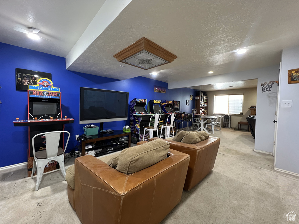 Carpeted living area featuring baseboards, a textured ceiling, and recessed lighting