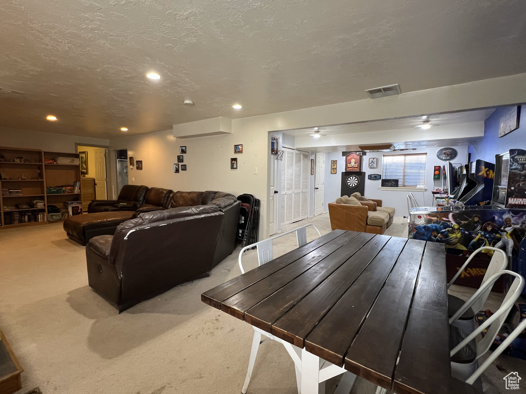 Carpeted dining space with recessed lighting and a textured ceiling