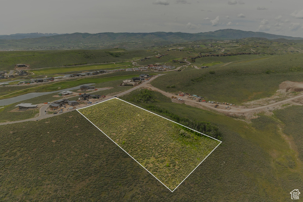 Aerial overview of property's location featuring a mountainous background and property parcel outlined