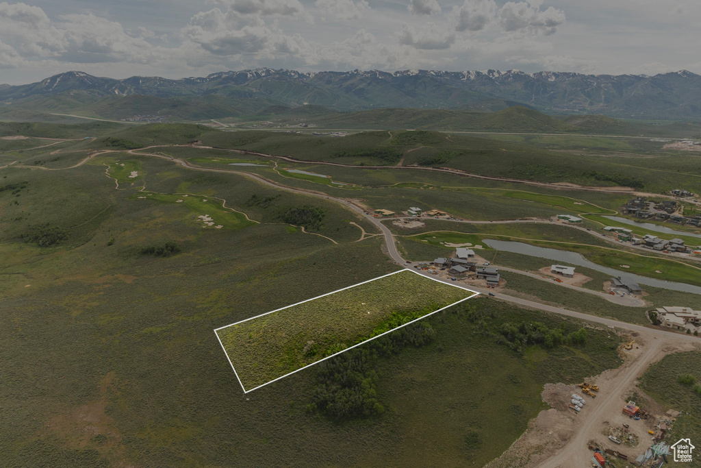 Aerial overview of property's location with a mountain backdrop and property boundaries highlighted