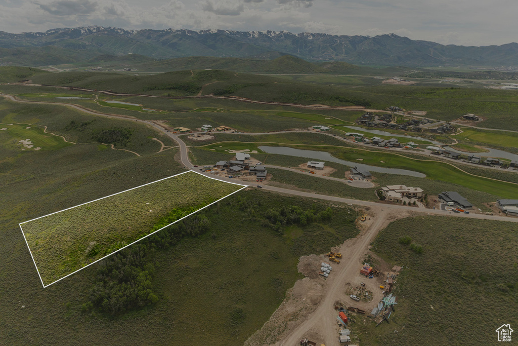 Aerial view of property and surrounding area featuring property parcel outlined and a mountainous background