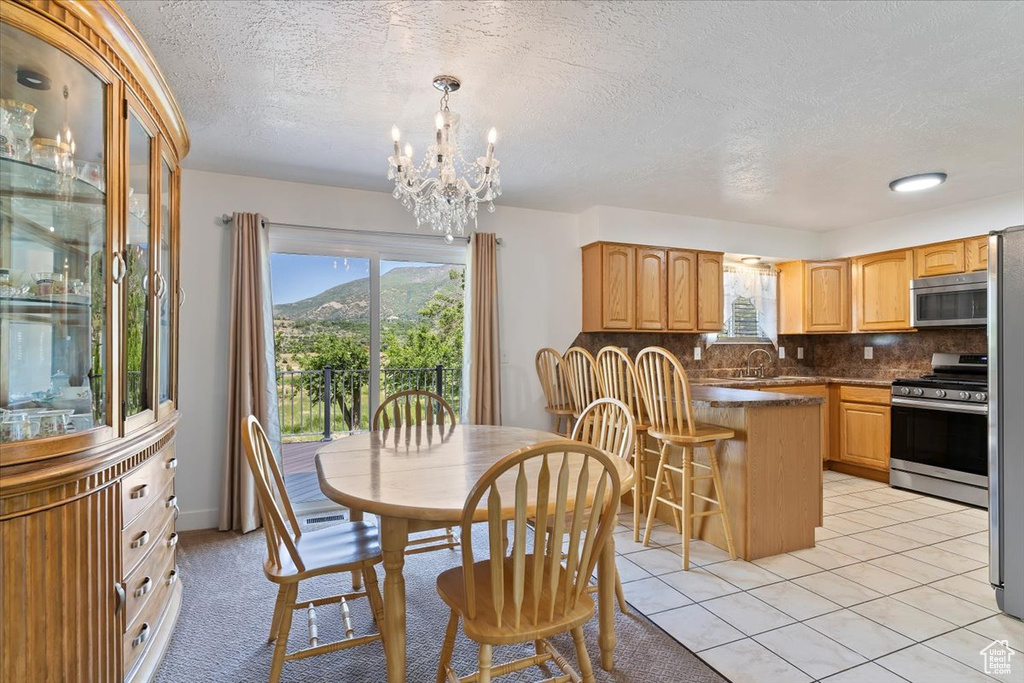 Dining space with a textured ceiling, a chandelier, and a mountain view
