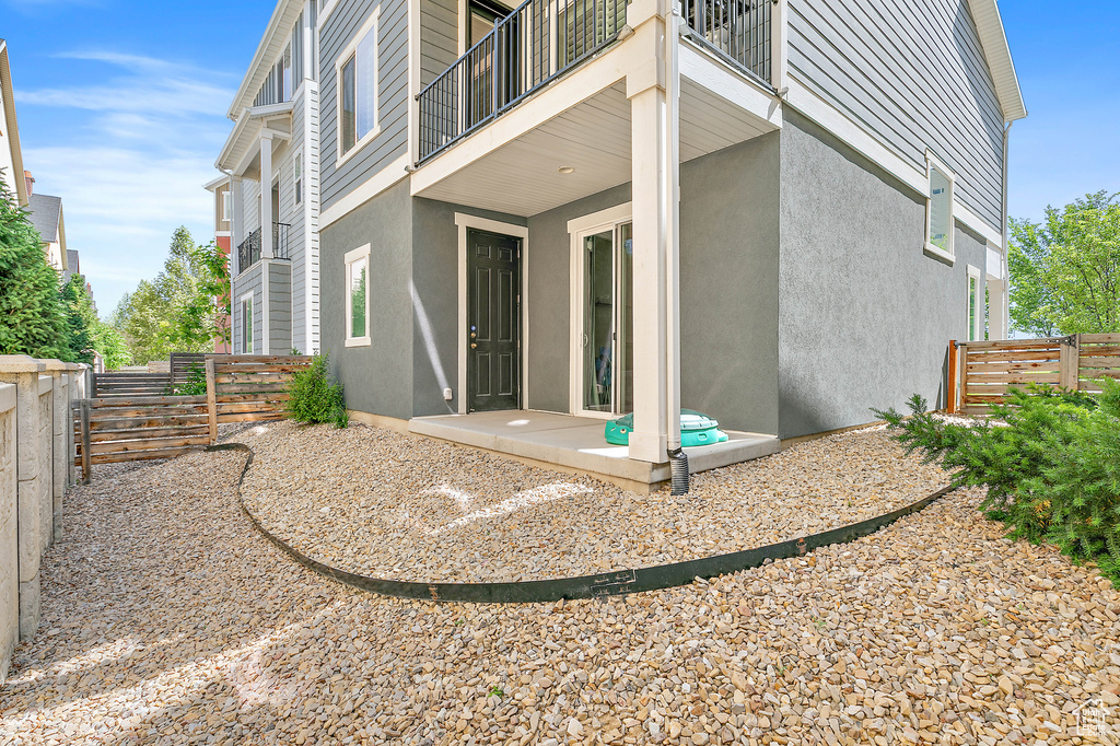 Rear view of property featuring a balcony and stucco siding