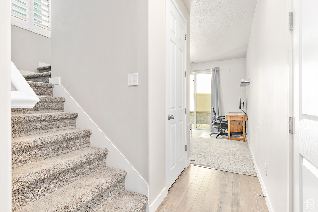 Stairway with wood-type flooring and baseboards