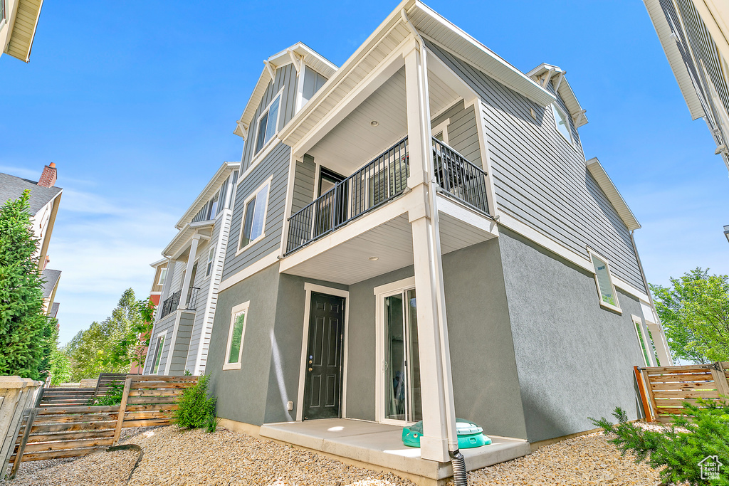 Rear view of property featuring a balcony and stucco siding