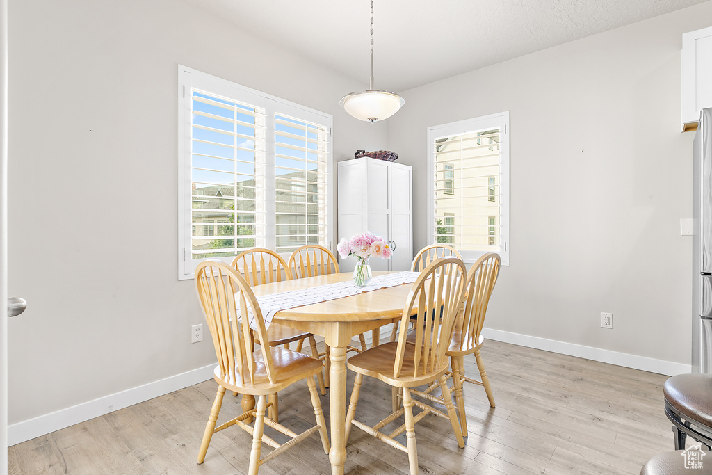 Dining room with light wood-style flooring and baseboards