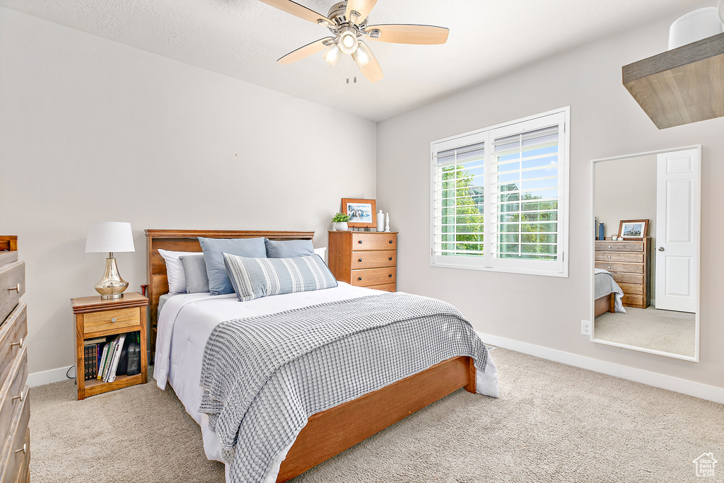 Carpeted bedroom with baseboards and ceiling fan