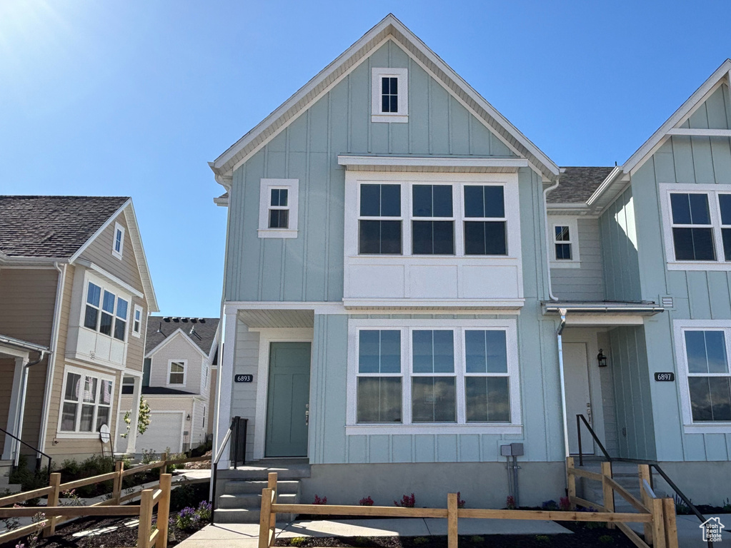 View of front of house with a fenced front yard, board and batten siding, and entry steps