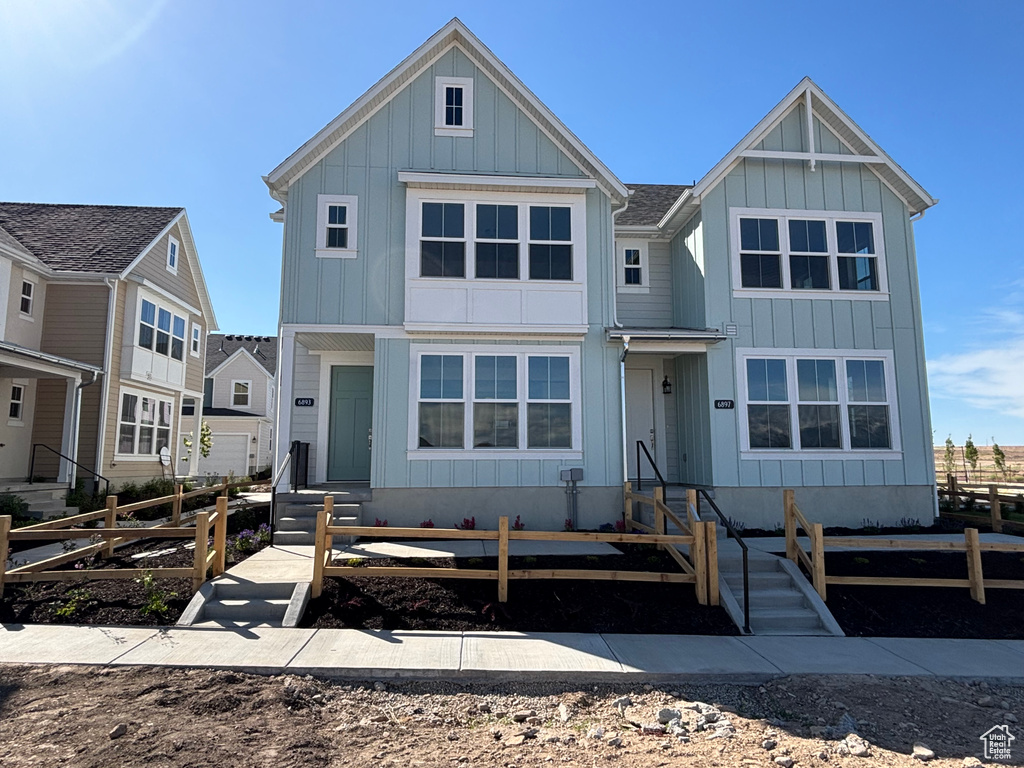 View of front facade with board and batten siding and entry steps