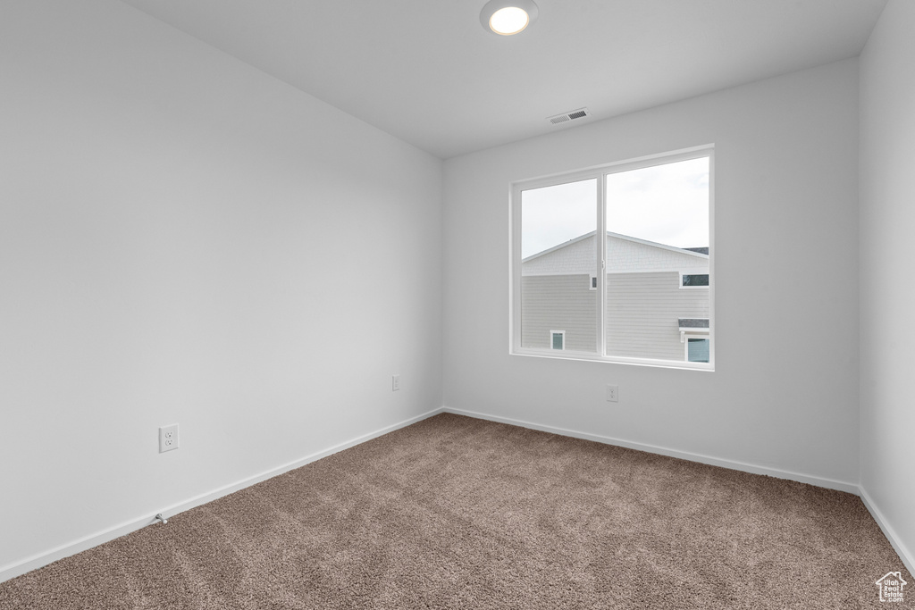 Unfurnished room featuring carpet floors and baseboards
