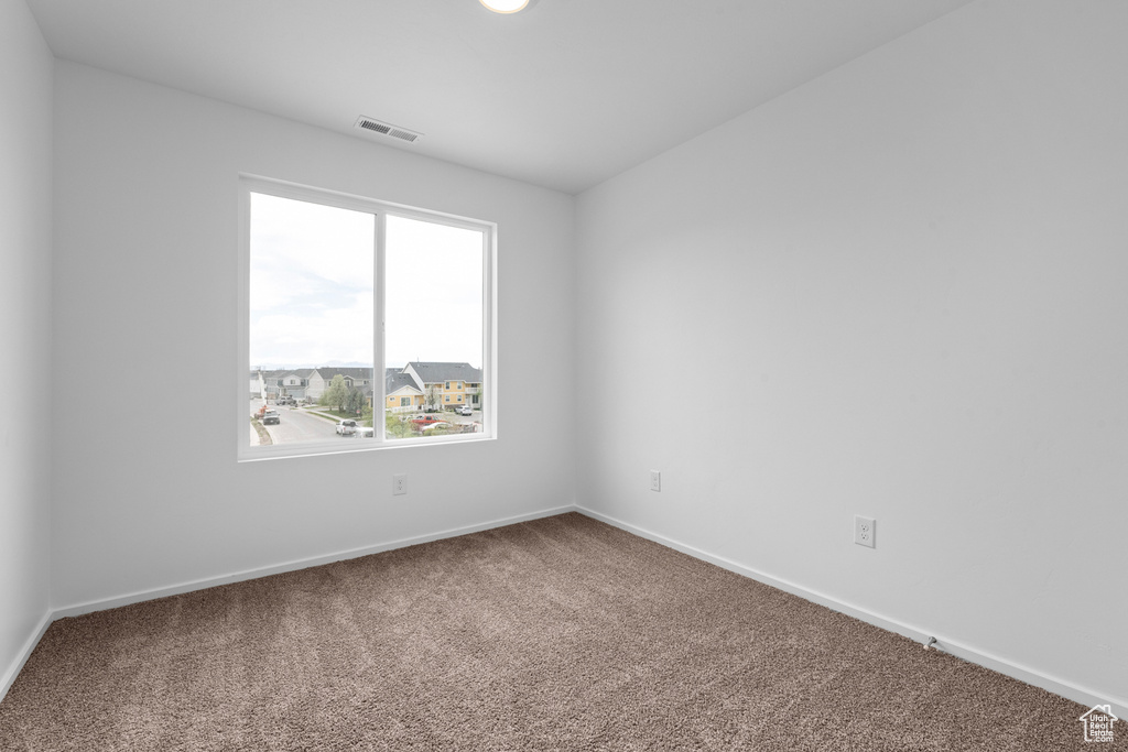 Carpeted empty room featuring baseboards