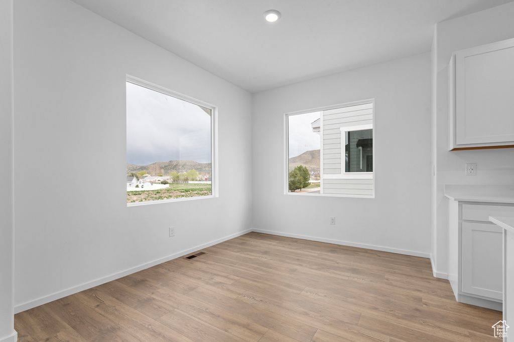 Empty room with light wood-type flooring and baseboards