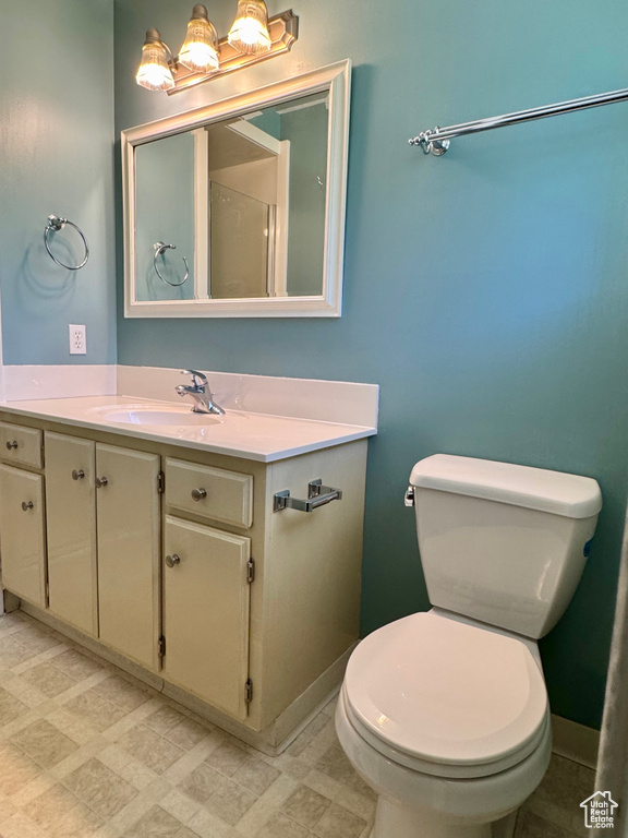 Bathroom with toilet, vanity, tile patterned floors, and baseboards